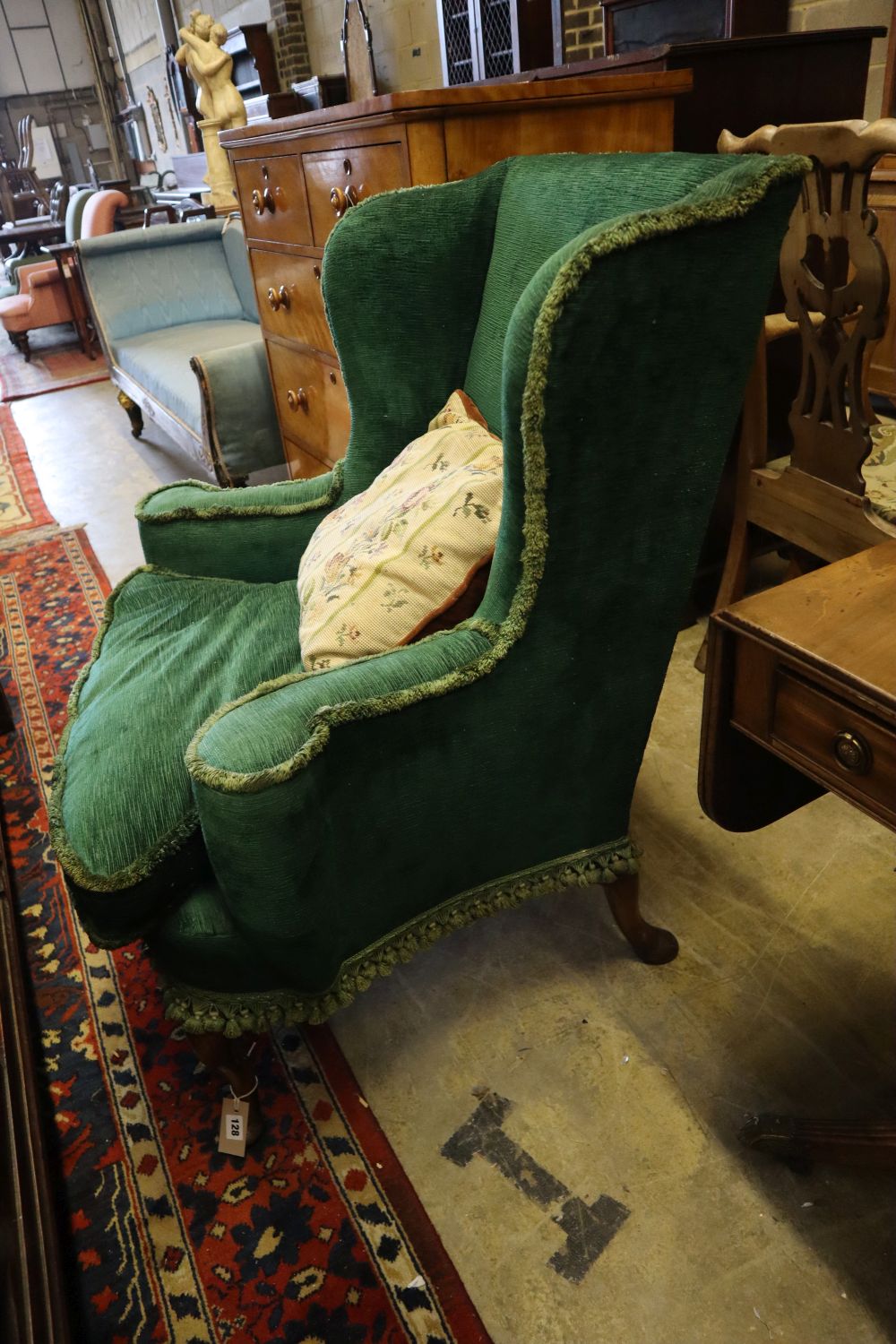 A George III style walnut upholstered wing armchair